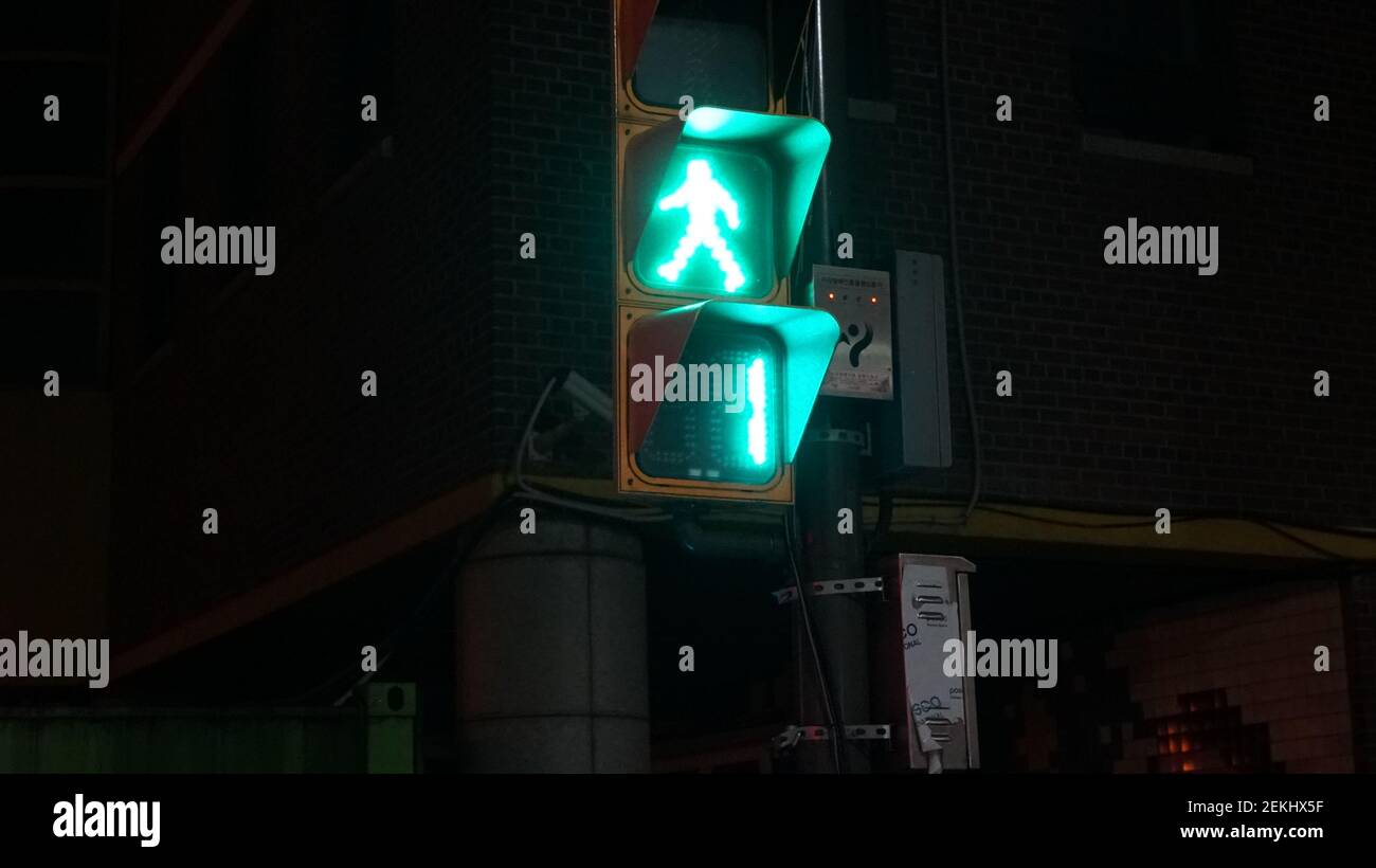 A Traffic Light just before Turning into a Red in the Night Streets of