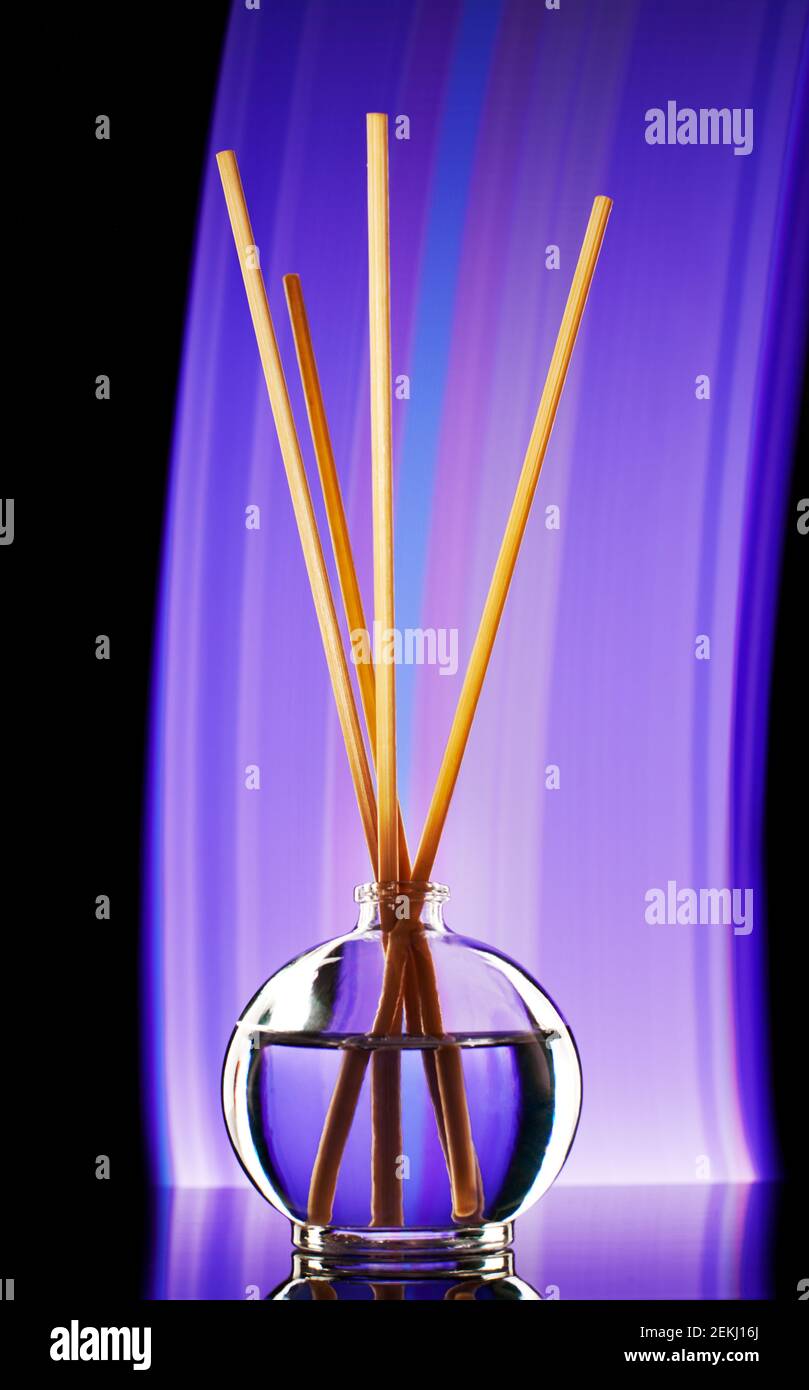 incense sticks in a jar of oil filmed with artificial decorative light