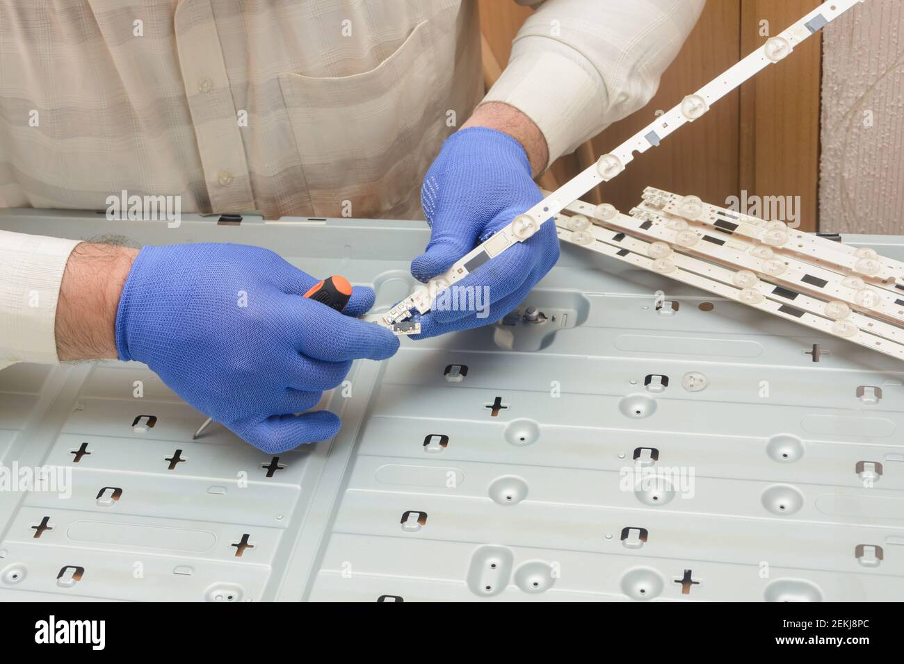 LCD TV repair. Engineer assembles LED board with lamps for large tv