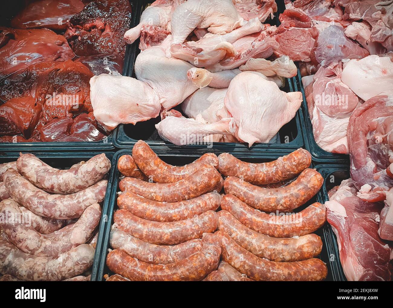 Assorted various fresh raw meat and meat products on market counter