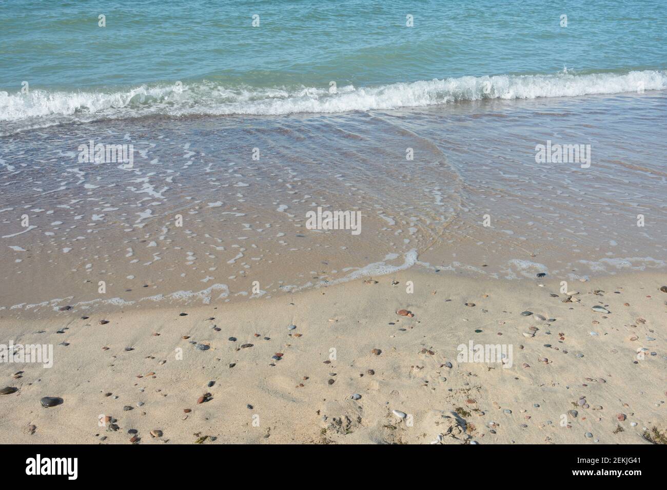 Soft wave with white foam, sea surf on sandy beach. Travel concept, sea vacation. Stock Photo