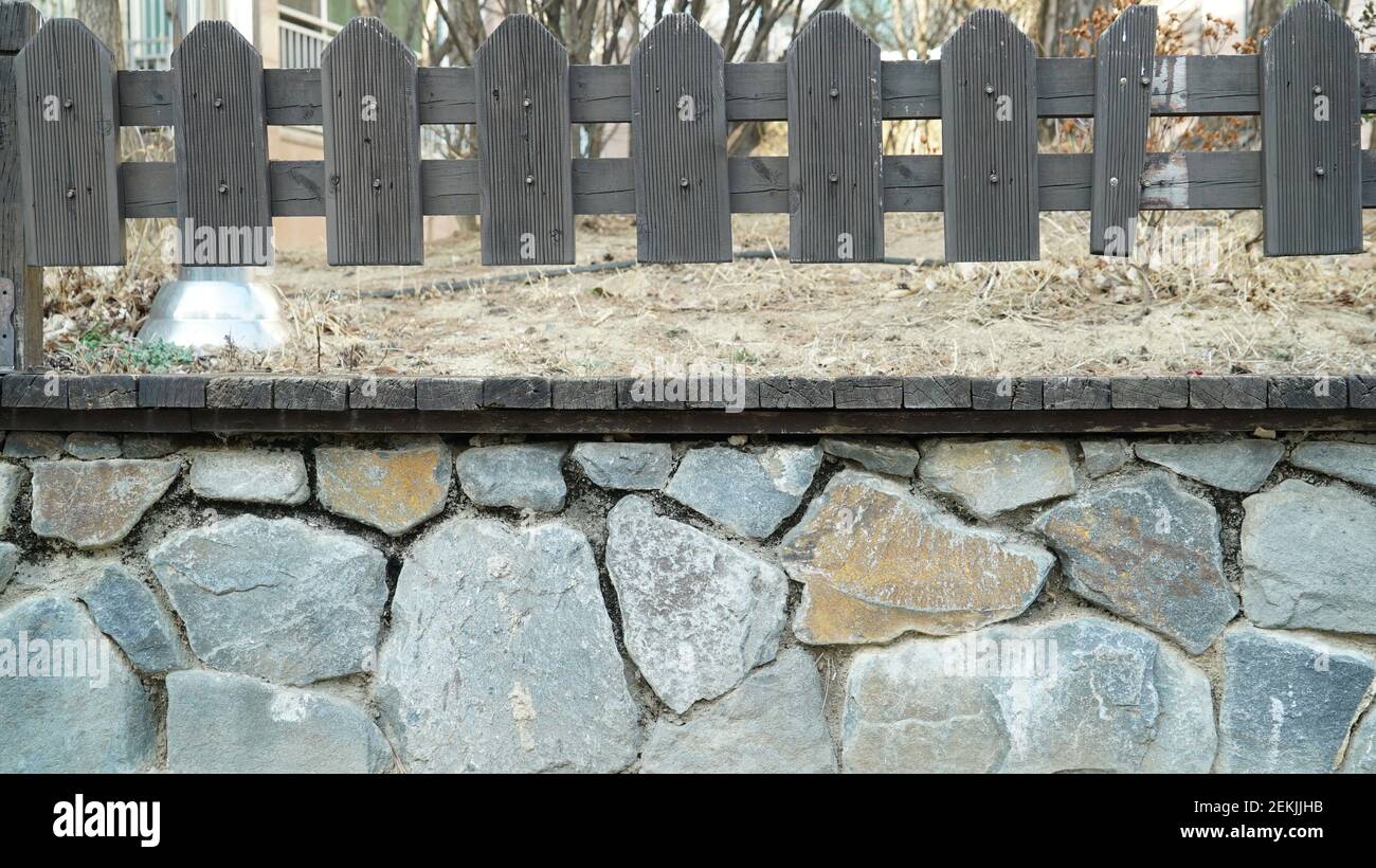 Stone wall and wooden fence Stock Photo