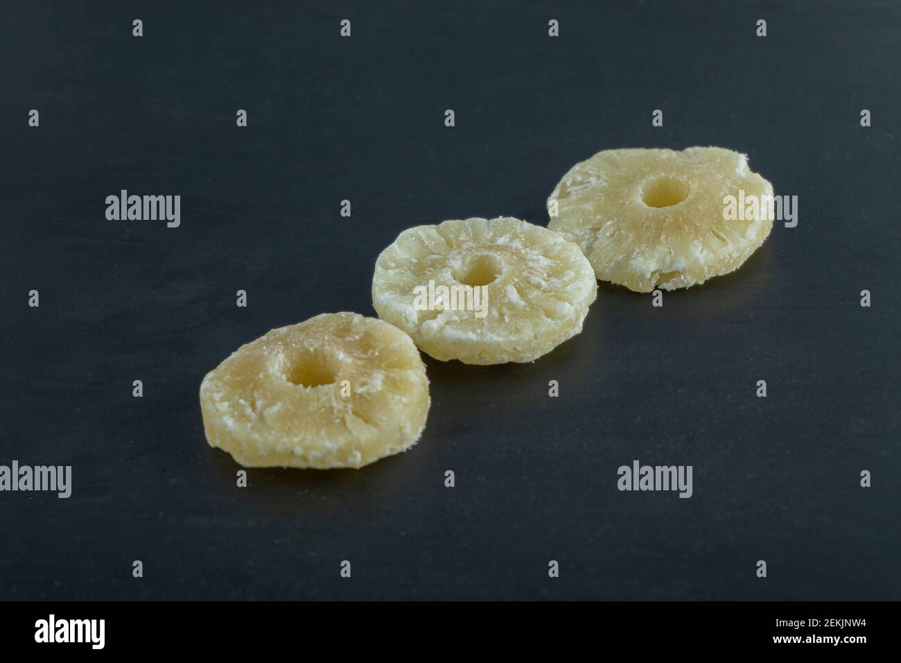 Dried pineapple slices on a dark background Stock Photo