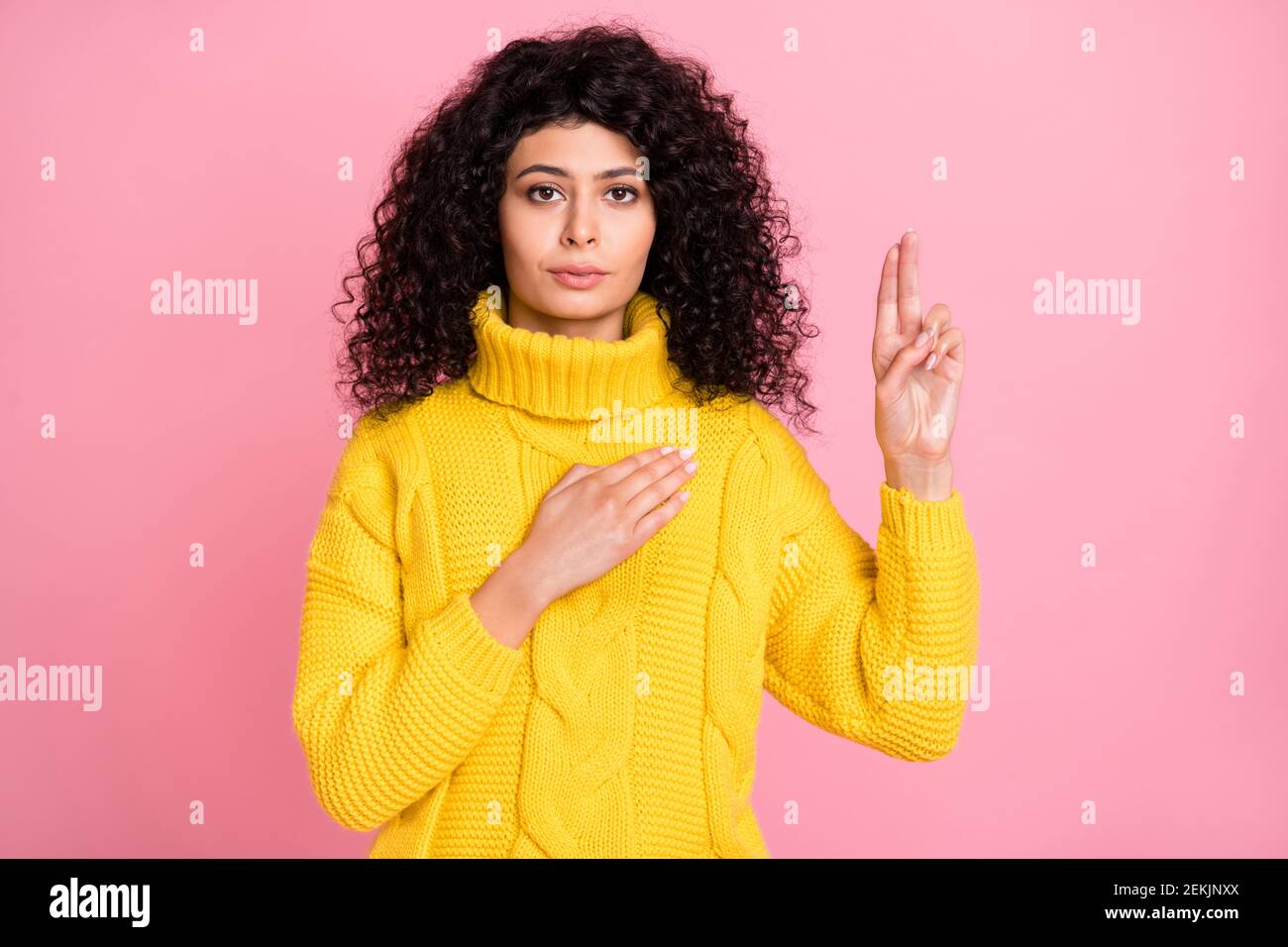 Photo of serious confident wavy lady dressed sweater arm chest swear to be honest rising two fingers isolated pink color background Stock Photo