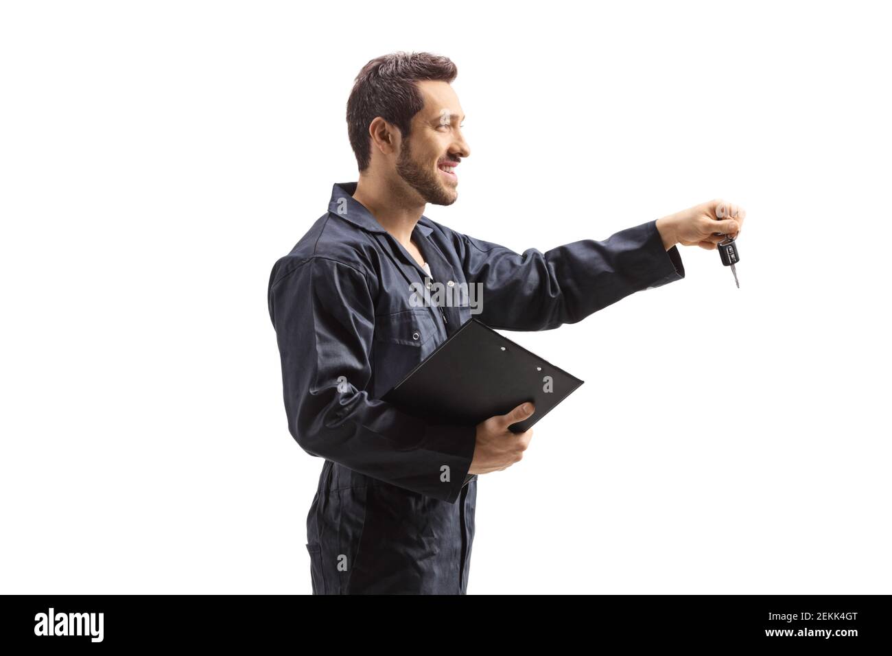 Mechanic in overalls holding a clipboard and car keys isolated on white background Stock Photo