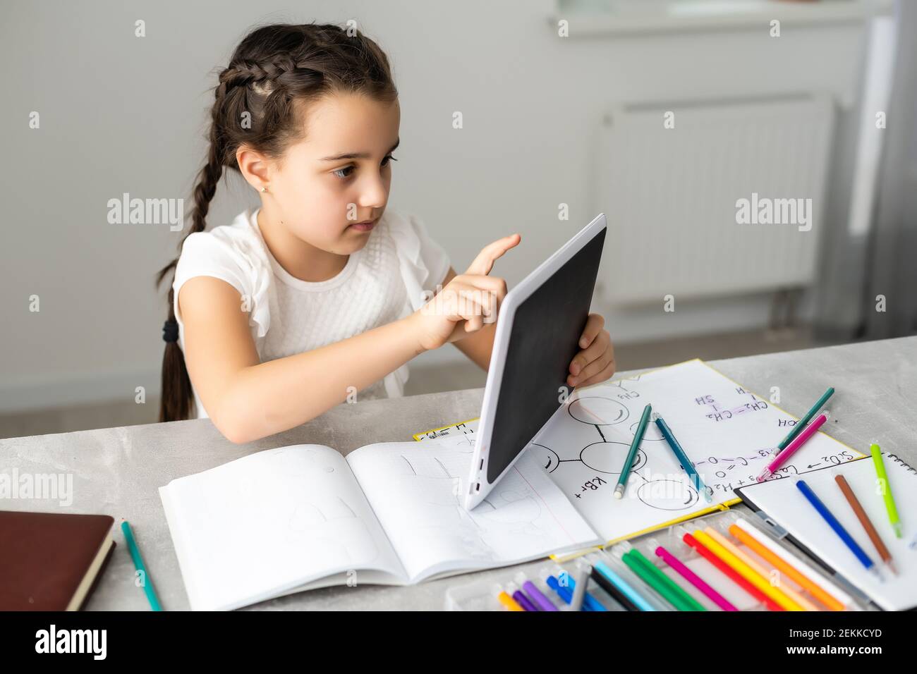 Cute little girl studying at home and smiling Stock Photo - Alamy