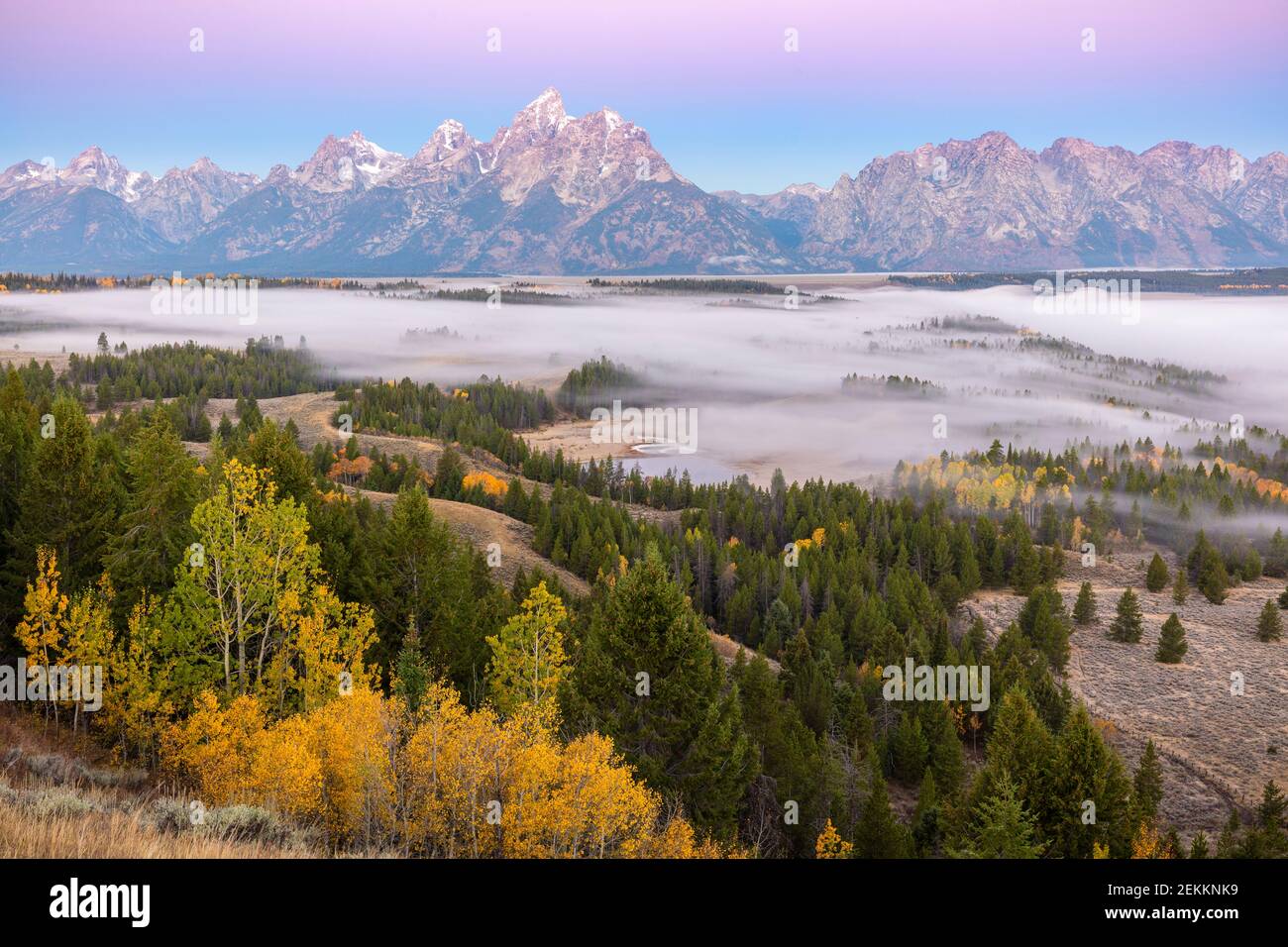 Grand Teton National Park, WY: Dawn light on the Teton Range with fog in the Snake River Valley in fall Stock Photo