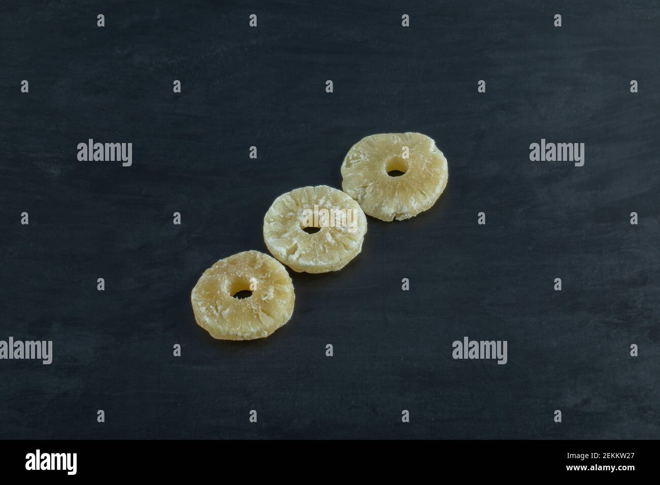 Dried pineapple slices on a dark background Stock Photo