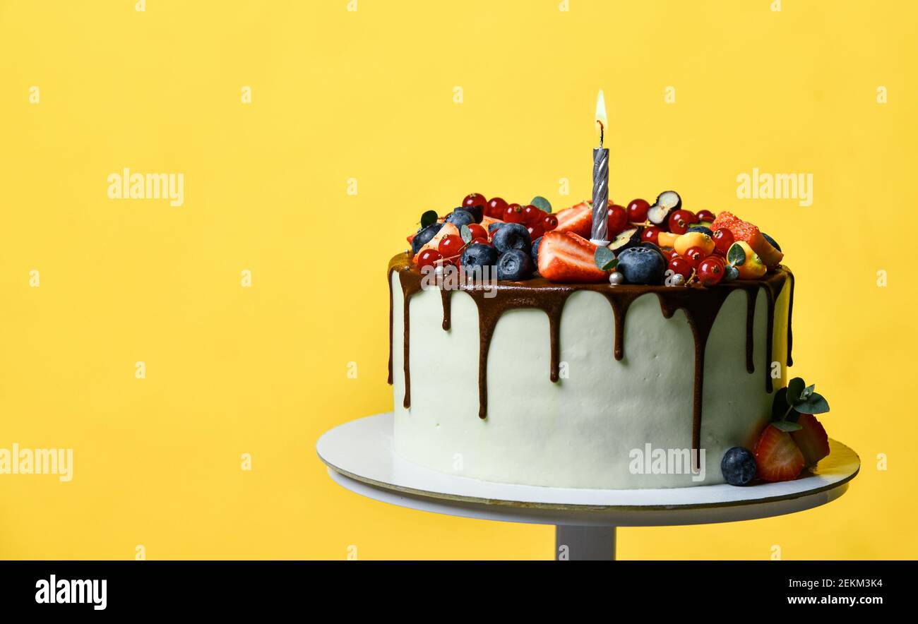 Birthday Party Sweet Cake With Chocolate Drips Fresh Fruits Raspberry Strawberry Blueberry Cranberry Cake With Lighted Candle Stock Photo Alamy