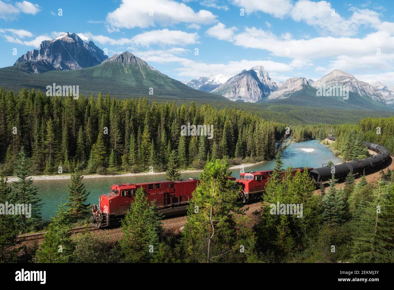 Red cargo train passing through Morant's curve in Bow Valley, Banff National Park, Alberta, Canada. Stock Photo