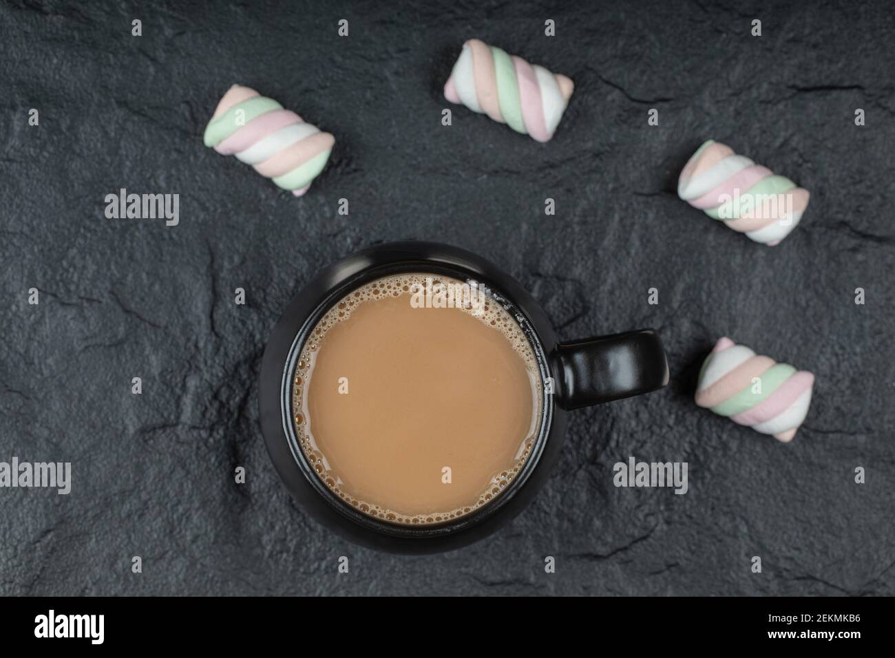 A black cup of coffee with marshmallows on a dark background Stock Photo