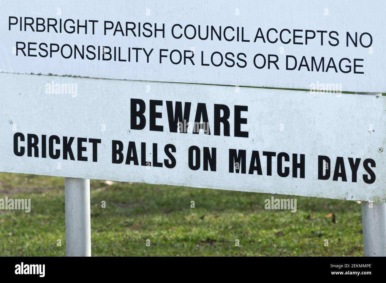 Sign in a car park next to a village cricket pitch warning Beware Cricket balls on match days, UK Stock Photo