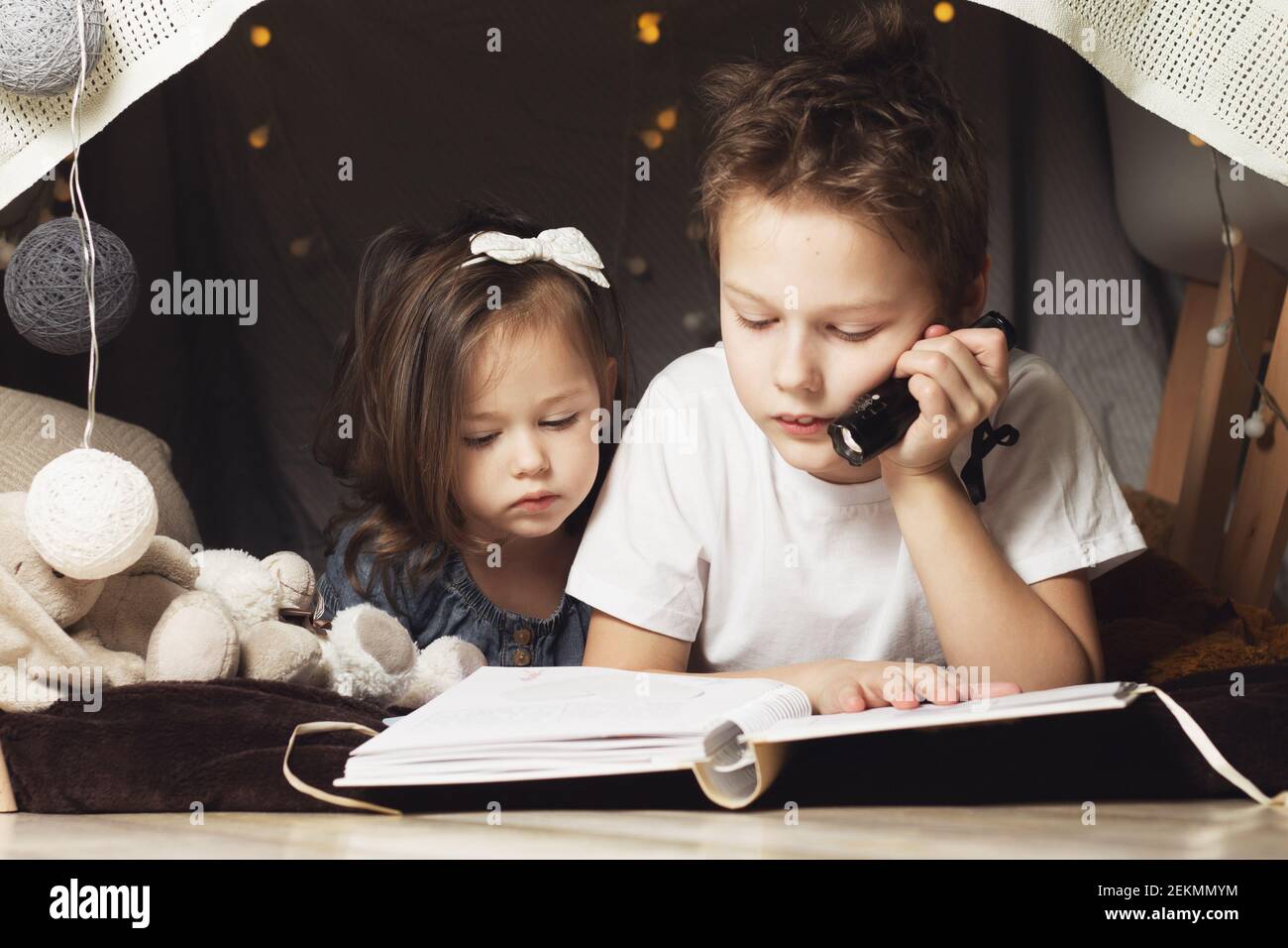 Siblings Lie In Hut Of Chairs And Blankets Brother And Sister Reading