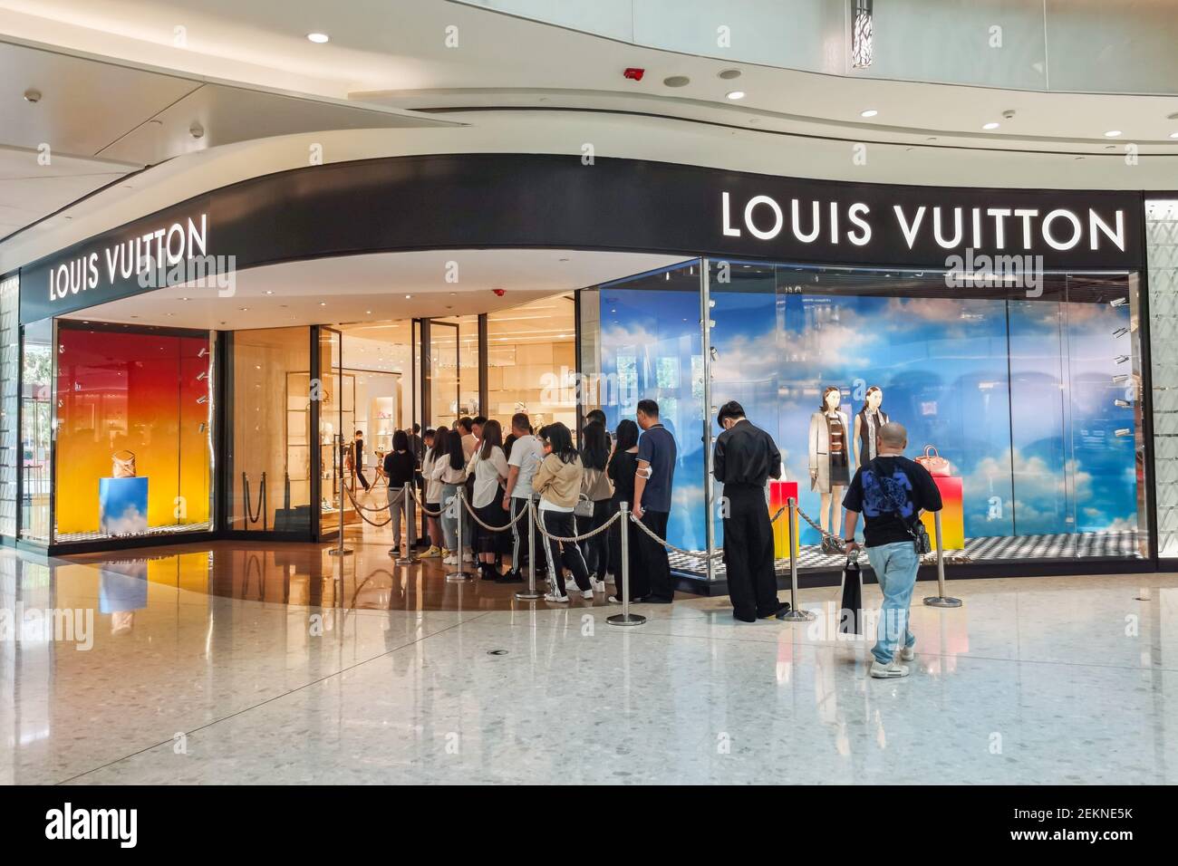 People line up as they wait to get in the Louis Vuitton shop on