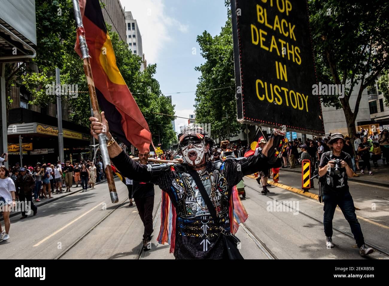 A protester holds a flag and a placard while marching through Swanston ...