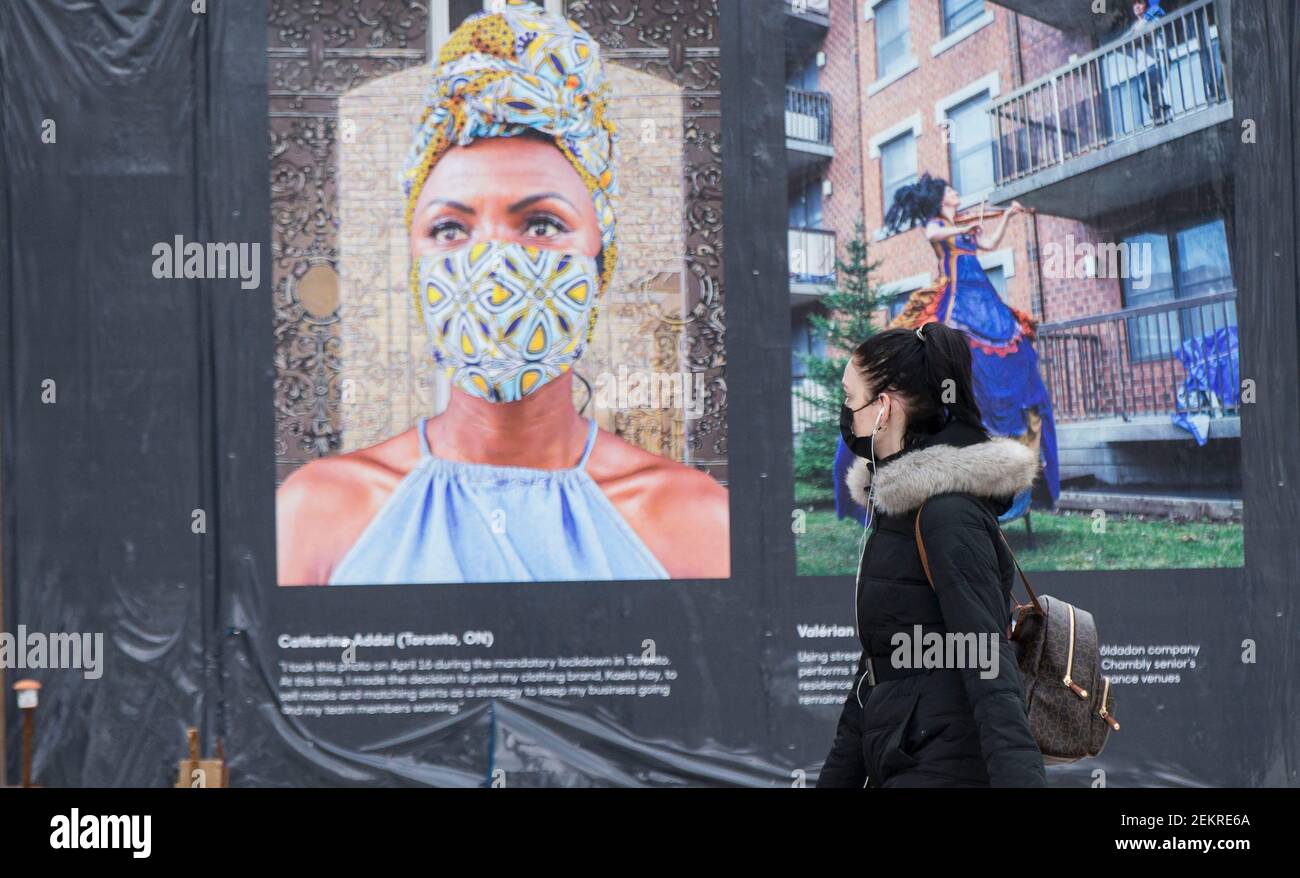 Toronto, Canada. 23rd Feb, 2021. A woman wearing a face mask walks past pictures 'Portraits in COVID Times' in Toronto, Canada, on Feb. 23, 2021. Canada's cumulative COVID-19 cases surpassed 850,000 as of Tuesday noon, with the total hitting 851,231, including 21,747 deaths, according to CTV. Credit: Zou Zheng/Xinhua/Alamy Live News Stock Photo