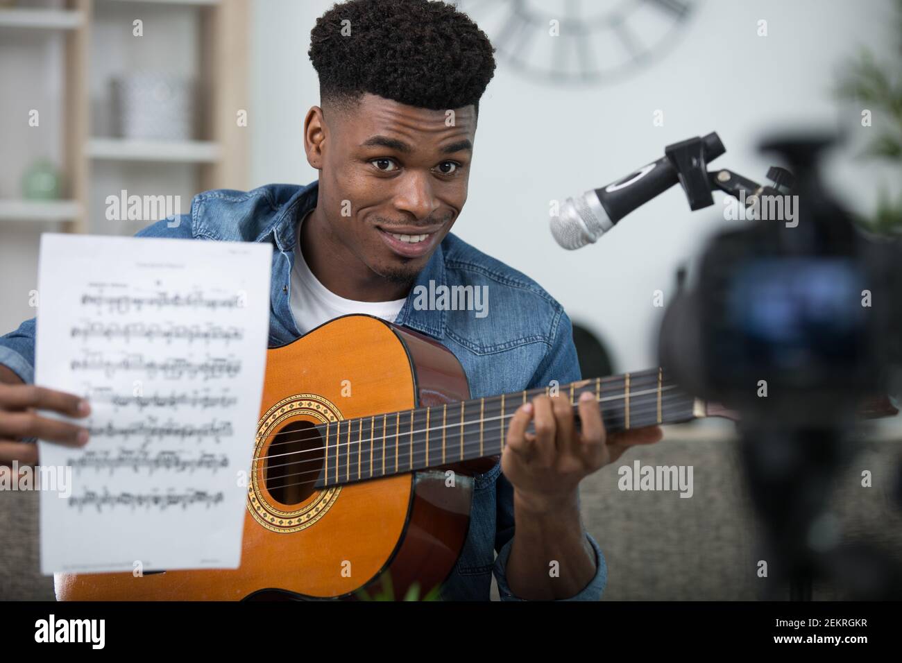 man showing how to play guitar with camera Stock Photo