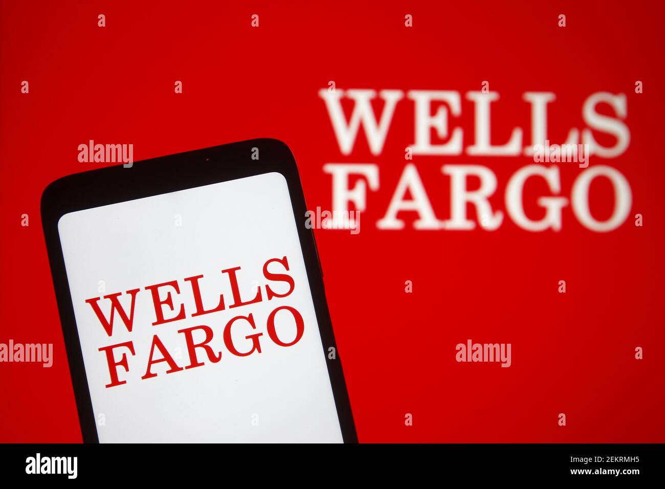 In this photo illustration, Wells Fargo logo of US financial services company is seen displayed on a smartphone and pc screen. Stock Photo