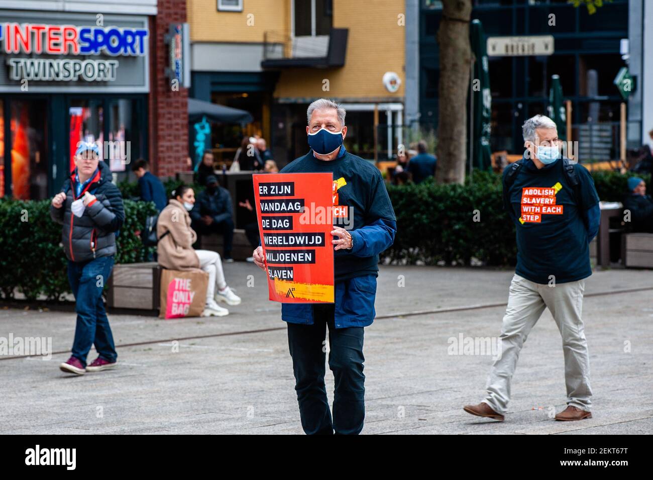 A volunteer wearing a face mask holds a placard during the demonstration.  Each year this silence march is organized around the world to draw  attention against human slavery and for a global