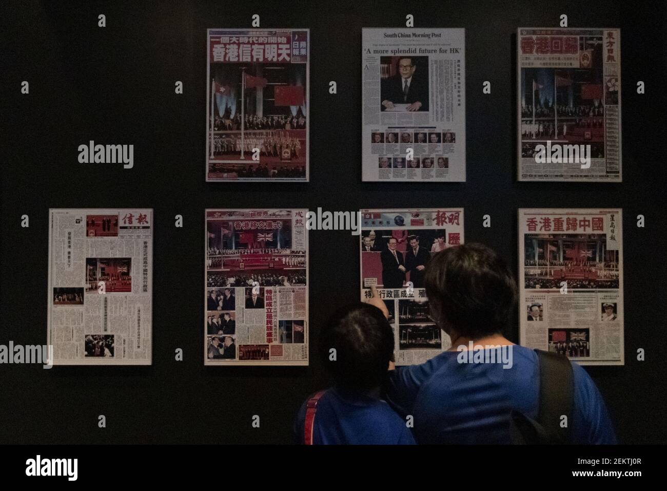 Visitors look at a wall of newspaper dated July 1st 1997 the day