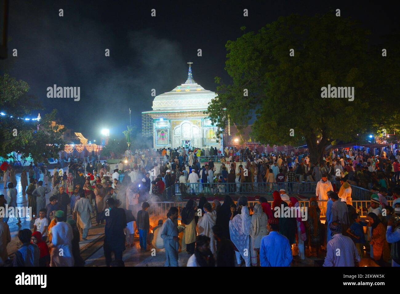 Pakistani Muslim devotees light candles and earthen lamps at the shrine