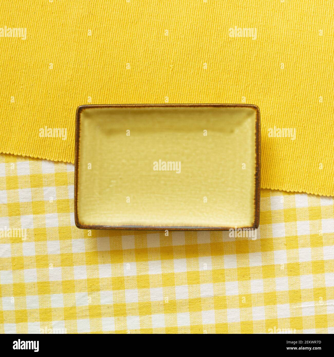 Empty plate on yellow fabric background. top view Stock Photo