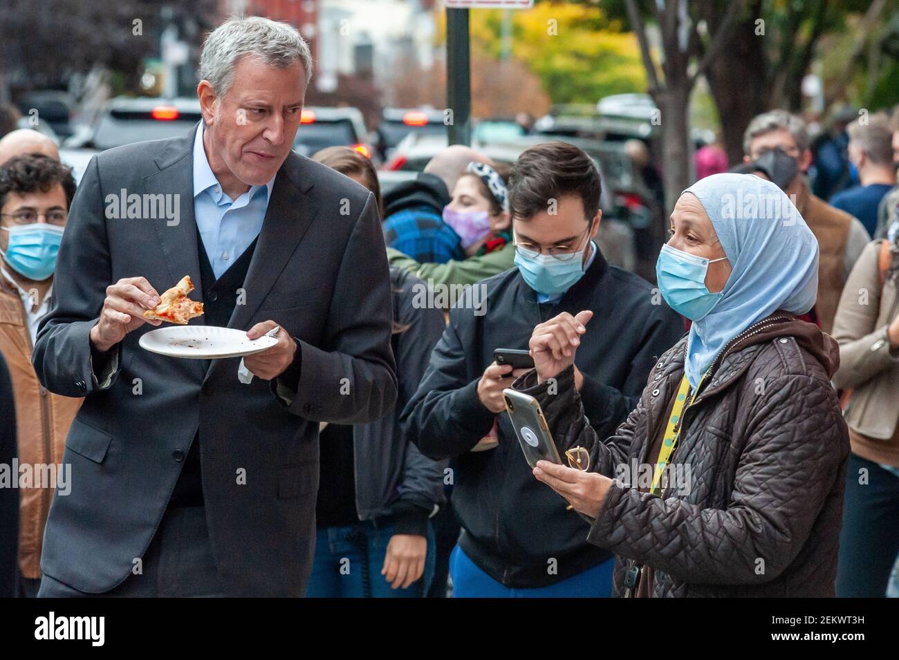 New York City Mayor Bill de Blasio eats a pizza with his hands while