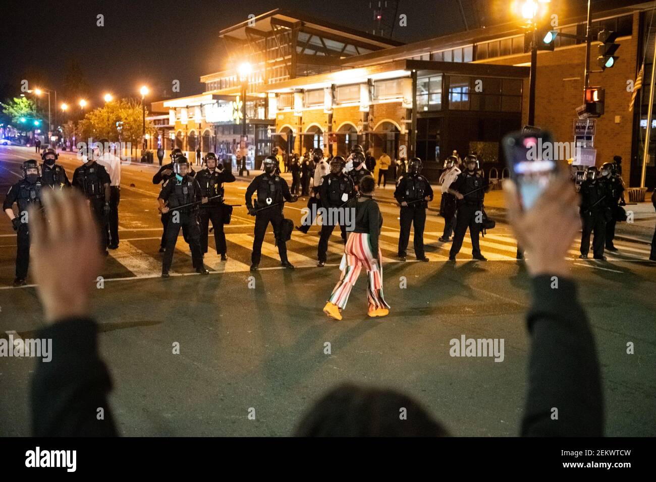 A demonstrator paces in front of a line of police during a protest that
