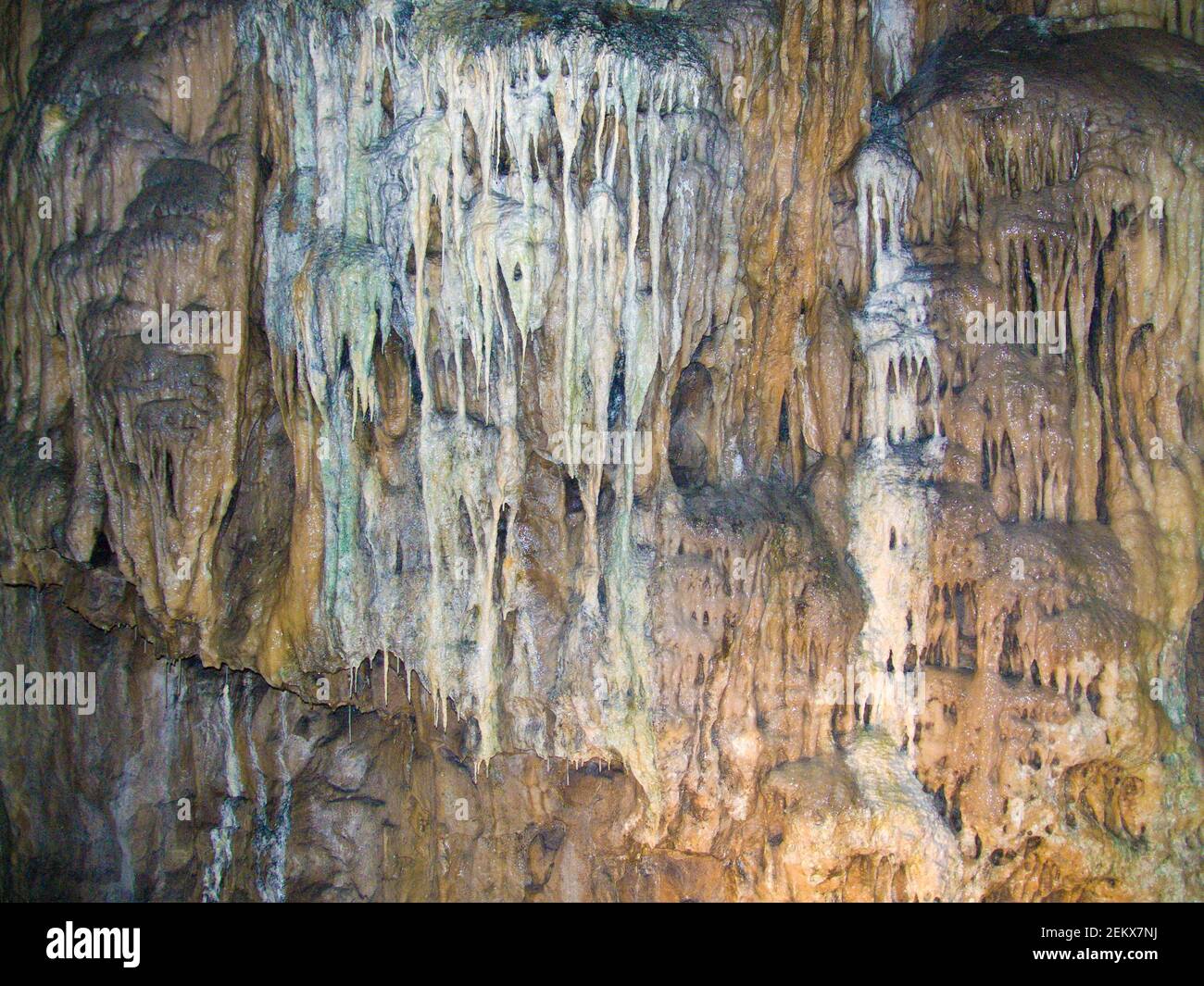 stalactites covering the wall of a cave, melting, icicles, creepy, water dripping, mineral formations Stock Photo