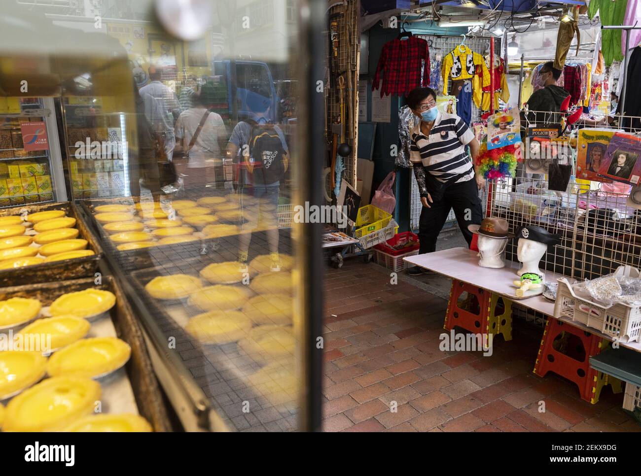 A vendor sells Halloween costumes and masks at his street store on