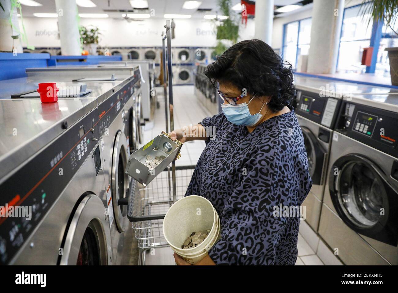 Laura Greco, a store leader, collects quarters from the washing machines at  Friendly Wash Laundromat in Chicago's Logan Square neighborhood on Oct. 29,  2020. (Photo by Jose M. Osorio/Chicago Tribune/TNS/Sipa USA Stock