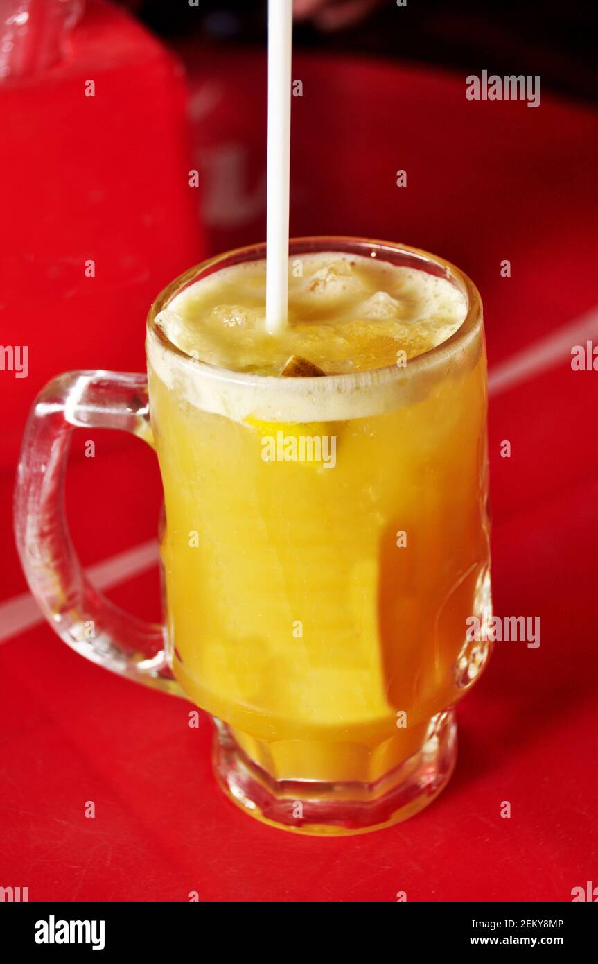 Fresh sugar cane juice and lime fruits with ice cube in glass cup burma