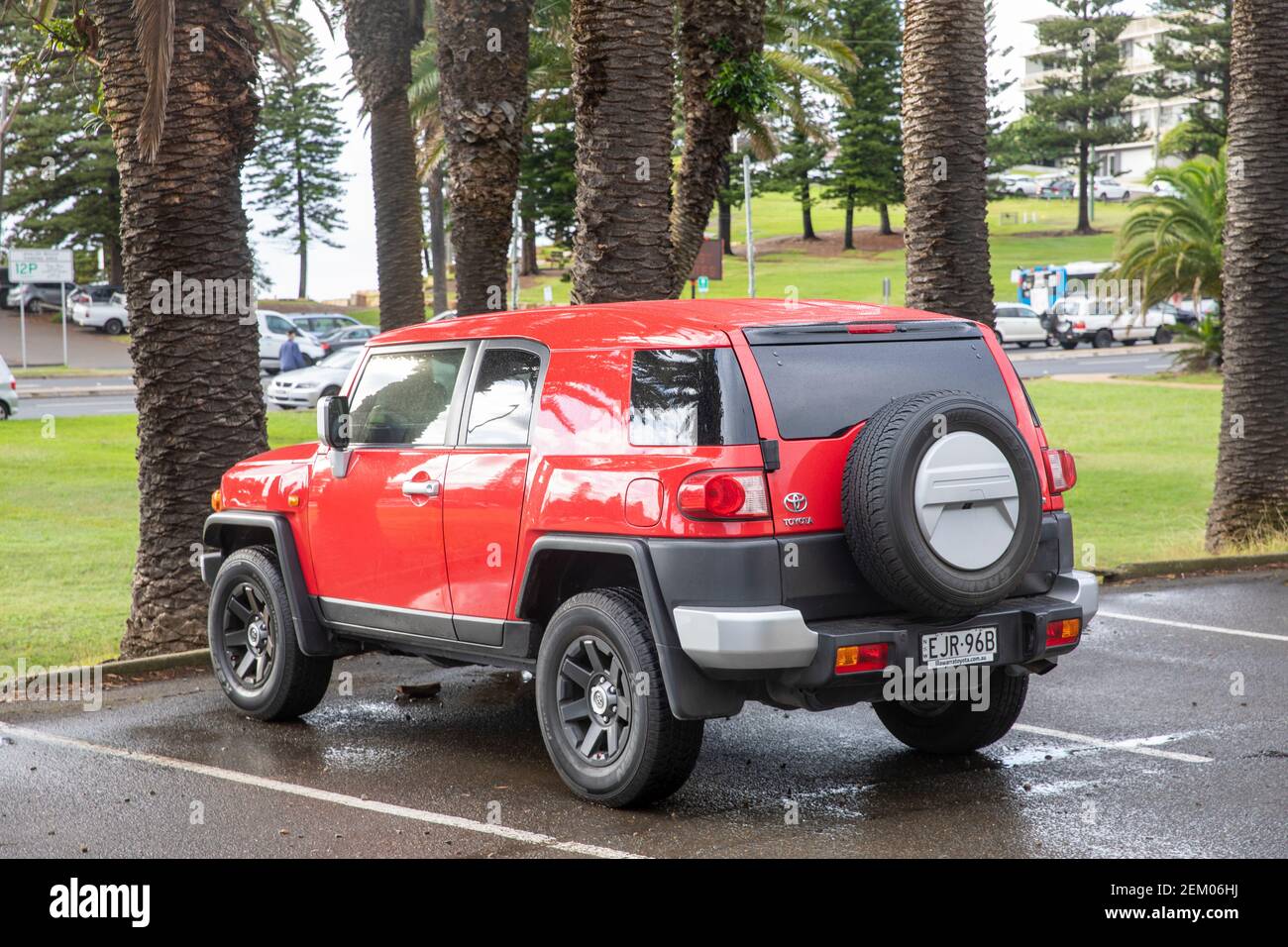 Red Toyota FJ Cruiser model car parked in Sydney beside palm trees