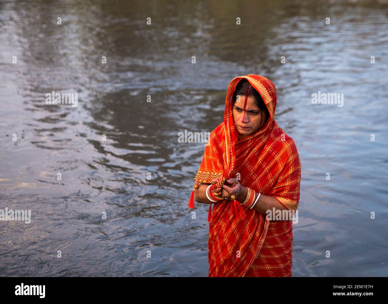 A devotee offering prayers as part of rituals during the celebration ...