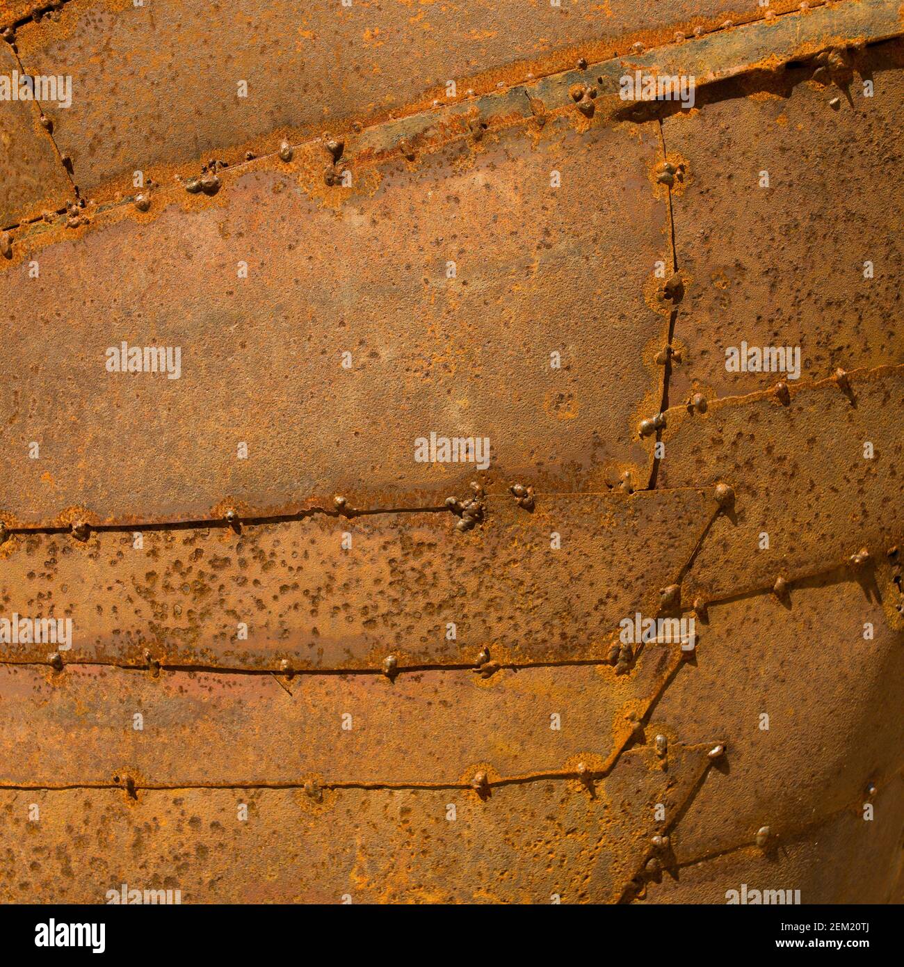 Rusty metal surface with weathered rivets showing signs of age in a close-up view, highlighting industrial texture and craftsmanship Stock Photo