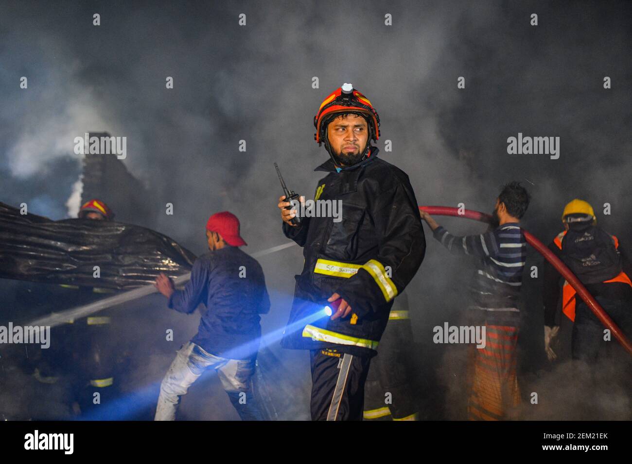 Firefighters and local people work together to extinguish a fire at a ...