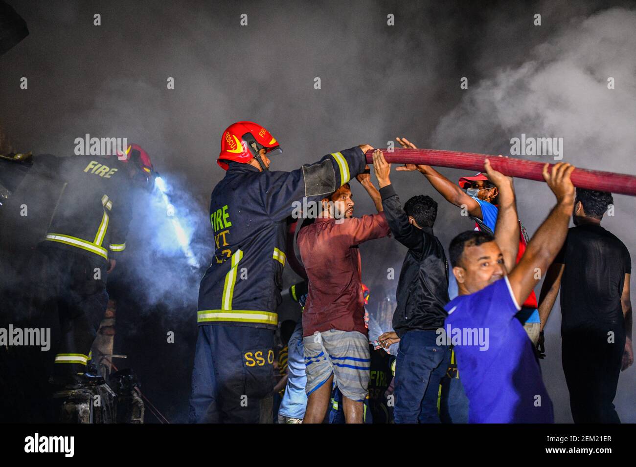 Firefighters and local people work together to extinguish a fire at a ...
