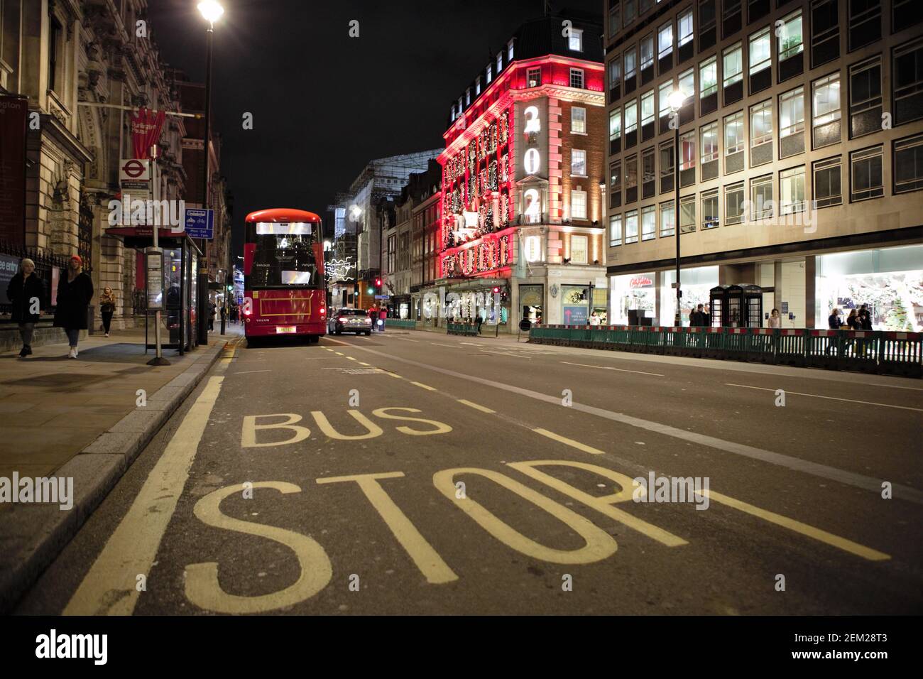 Christmas lights are lit up on Piccadilly London. People are getting