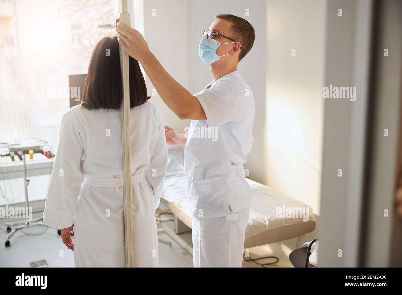 Physician using a stadiometer in a routine medical examination Stock Photo