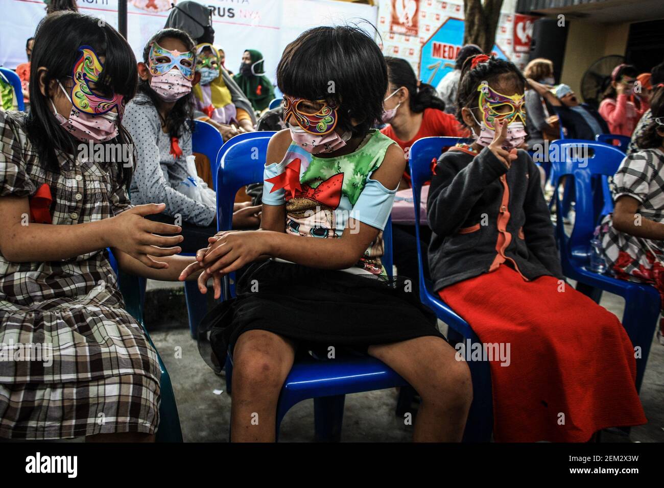 Children wore masks, red ribbon tags (symbol for AIDS awareness) and ...