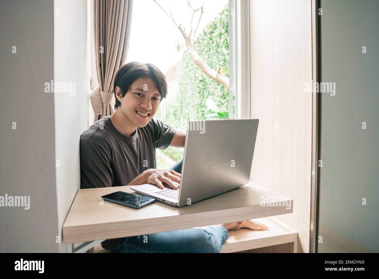 handsome asian modern man designer working home using laptop at home Stock Photo