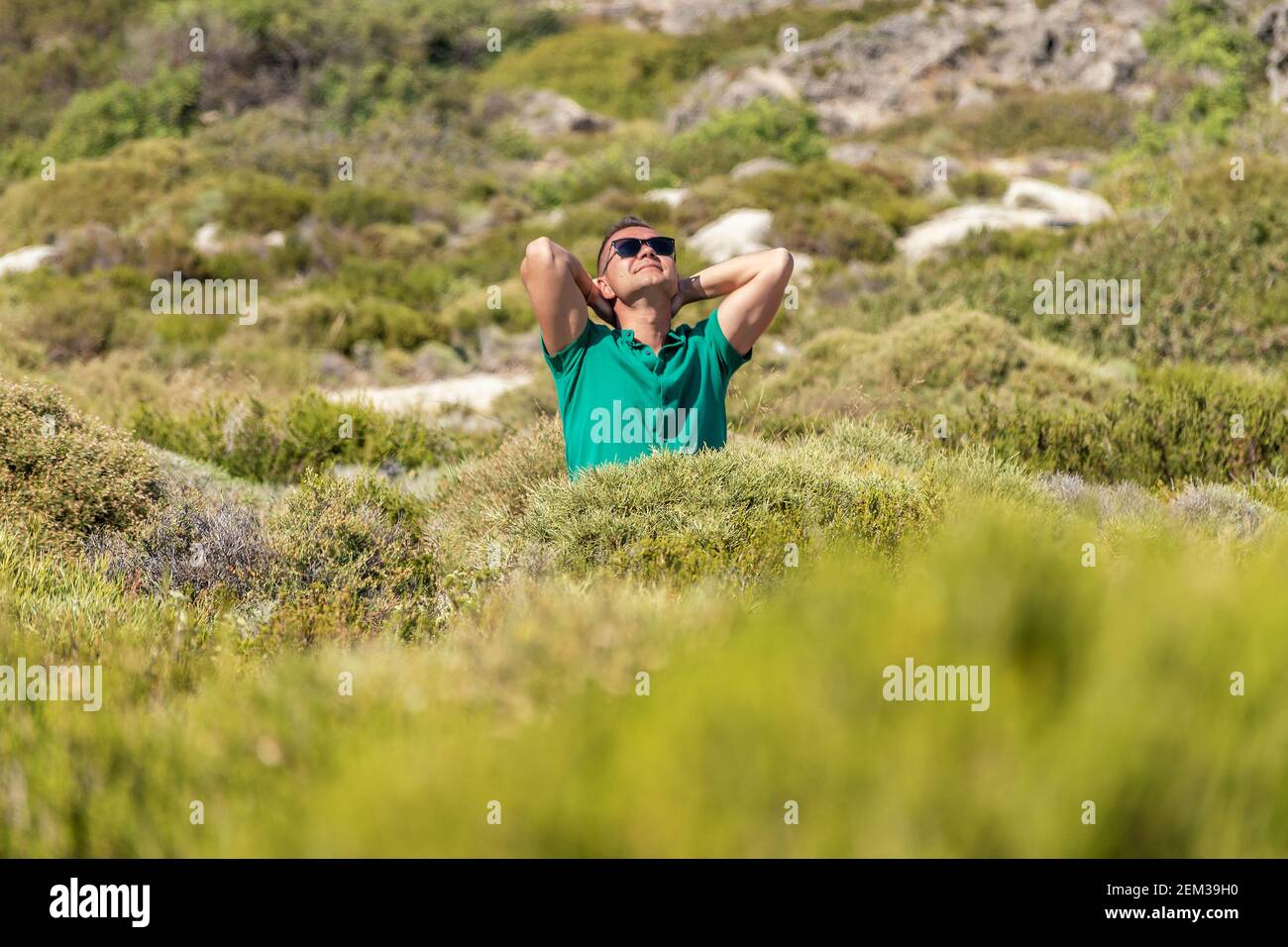 Happy guy in a green field in a shirt. Stock Photo