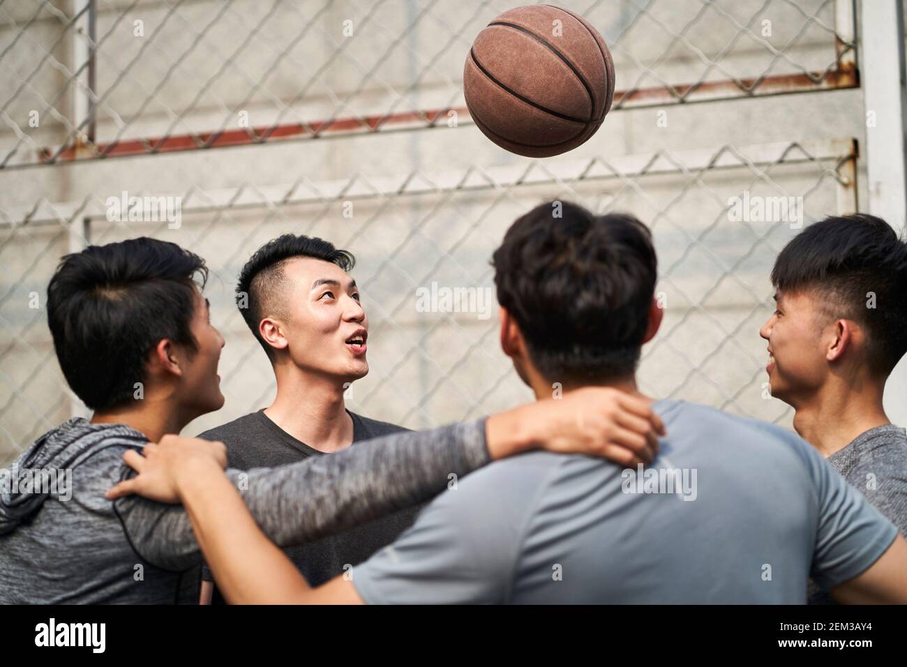 young asian adult men having fun playing with basketball outdoors Stock Photo