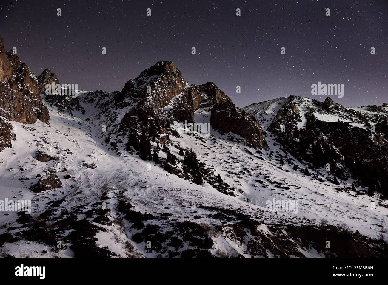 Dramatic landscape of mountain range at night sky with stars near Almaty, Kazakhstan Stock Photo