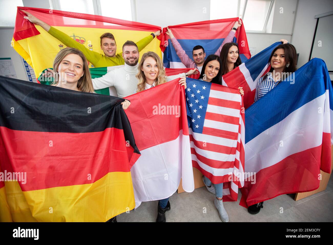 Group of young people holding international flags of many countries in