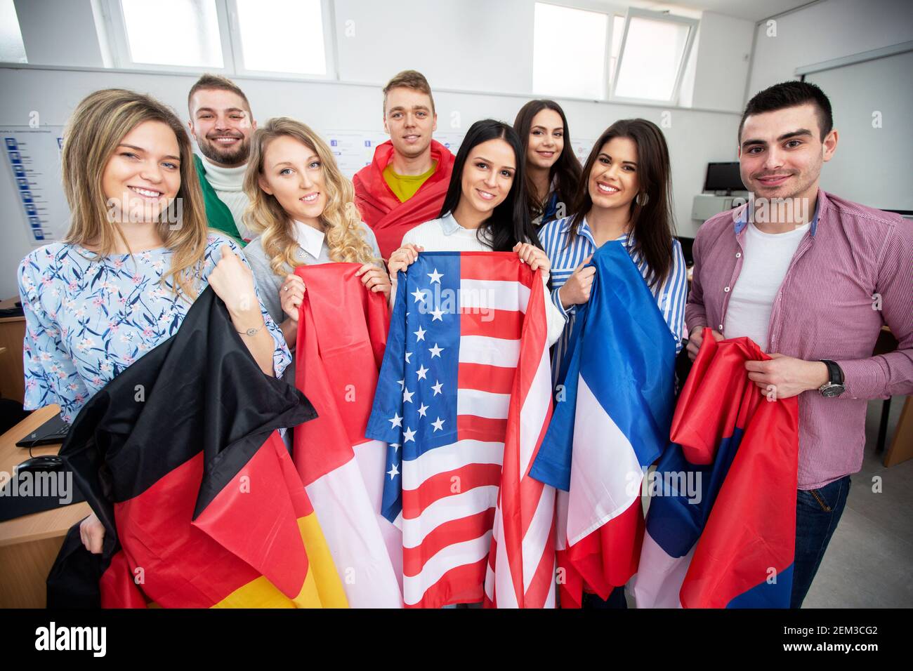 Group of young people holding international flags of many countries in