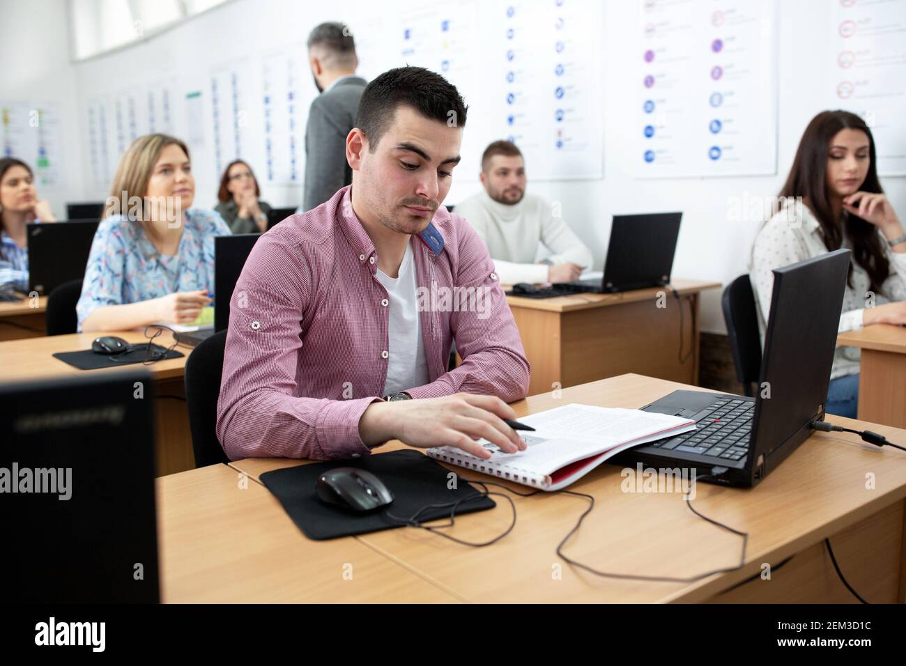 Young man sitting in the class studying his notes, student concept Stock Photo