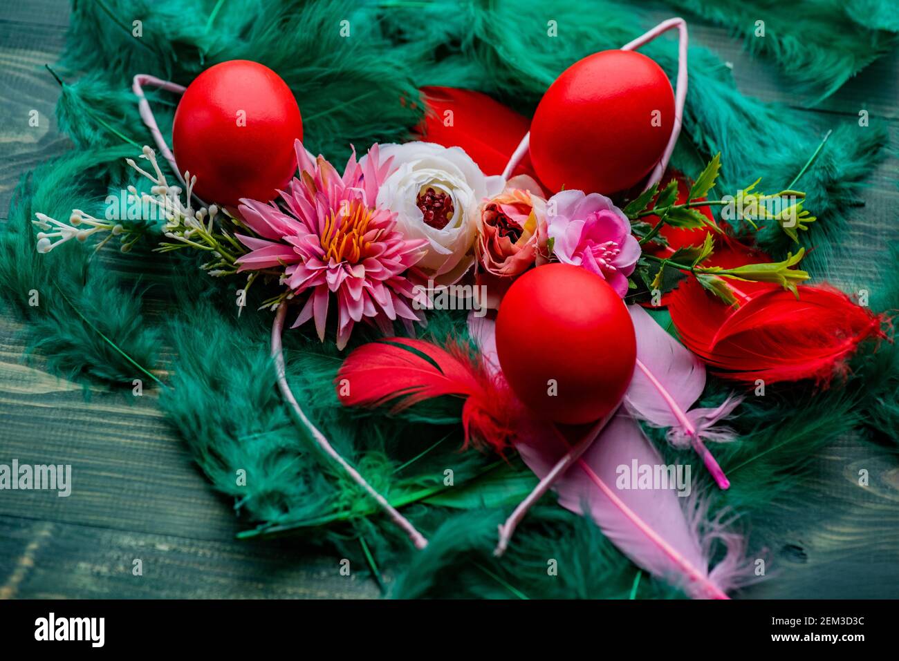 Easter eggs. Colored egg. Easter. Red eggs on green feathers Stock Photo