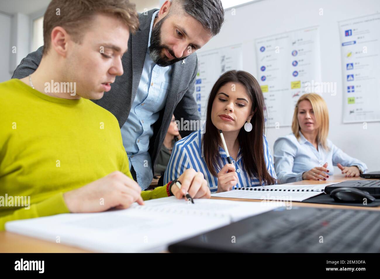 Driving instructor in classroom introducing students with driving