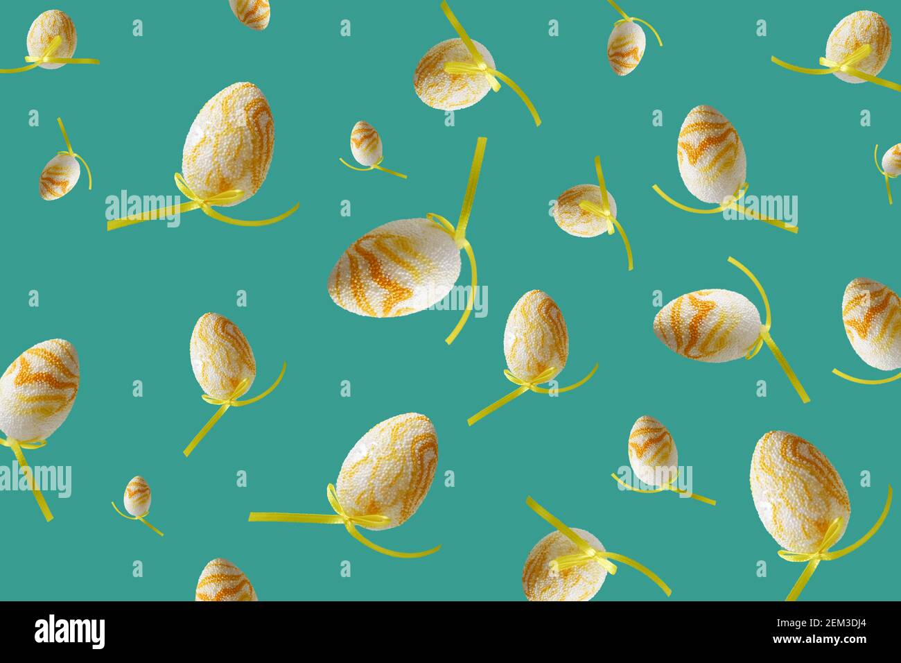 Spring pattern with flying yellow eggs on turquoise background. Zero gravity easter concept. Stock Photo